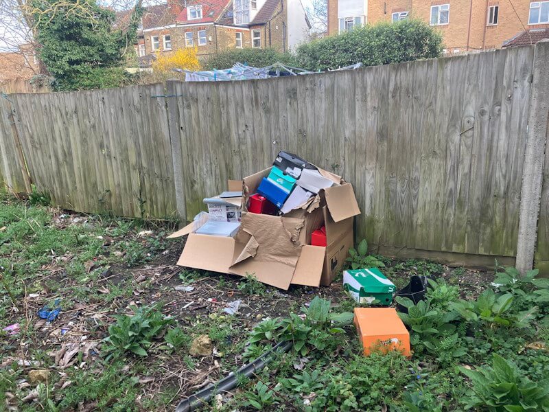 Mixed garden waste and cardboard boxes requiring removal in Penge garden