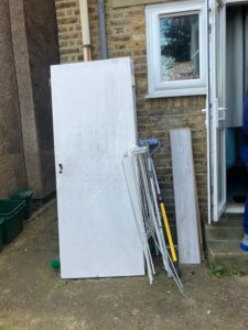 Household items including door and furniture for disposal outside Penge home