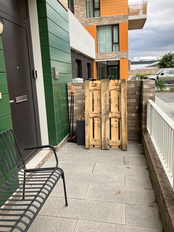 Wooden pallets being prepared for loading during rubbish removal service at modern residential development in Greenwich SE10