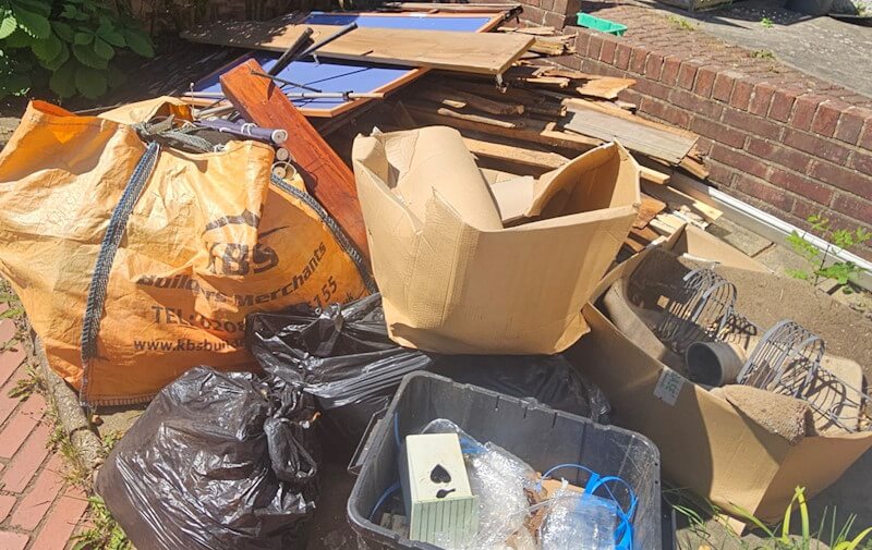 Close-up household rubbish removal Eltham - cardboard, builder's bags, metal coils, black refuse sacks
