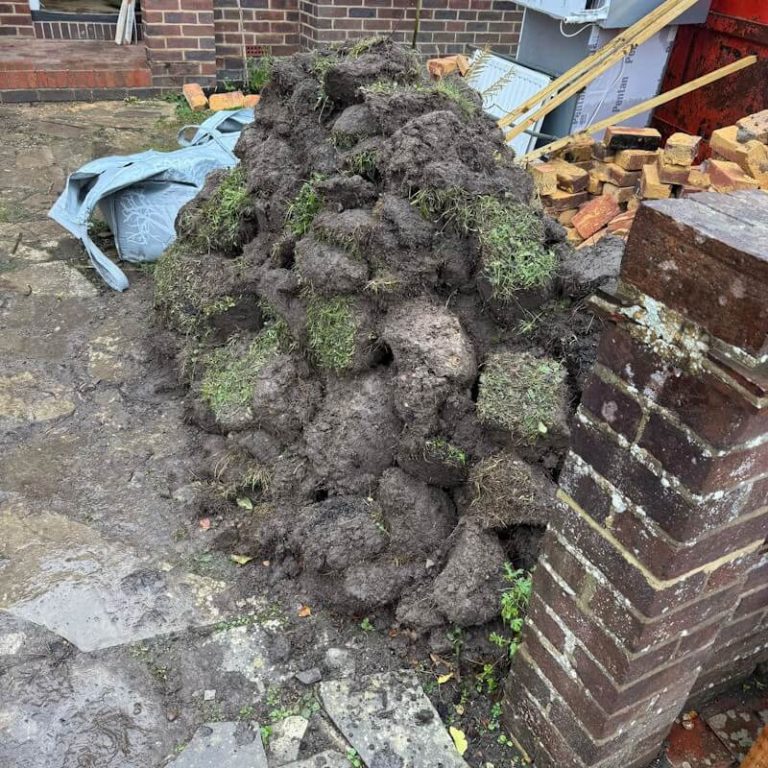 Garden clearance showing removed turf soil and construction waste during residential renovation project