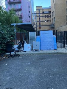 Rubbish removal Elephant and Castle SE1 — office chairs, mattresses and white goods staged in estate courtyard awaiting collection