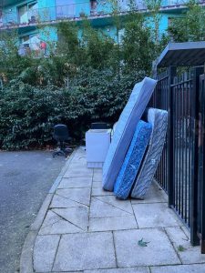 Mattresses and bulky waste beside estate railings before collection — rubbish removal Elephant and Castle SE1