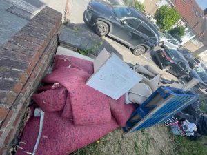 Stacked wooden furniture pieces and household items cleared in Shooter's Hill