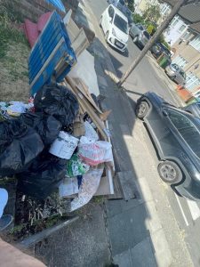 Black bin bags and cardboard waste stacked for clearance in Shooter's Hill SE18